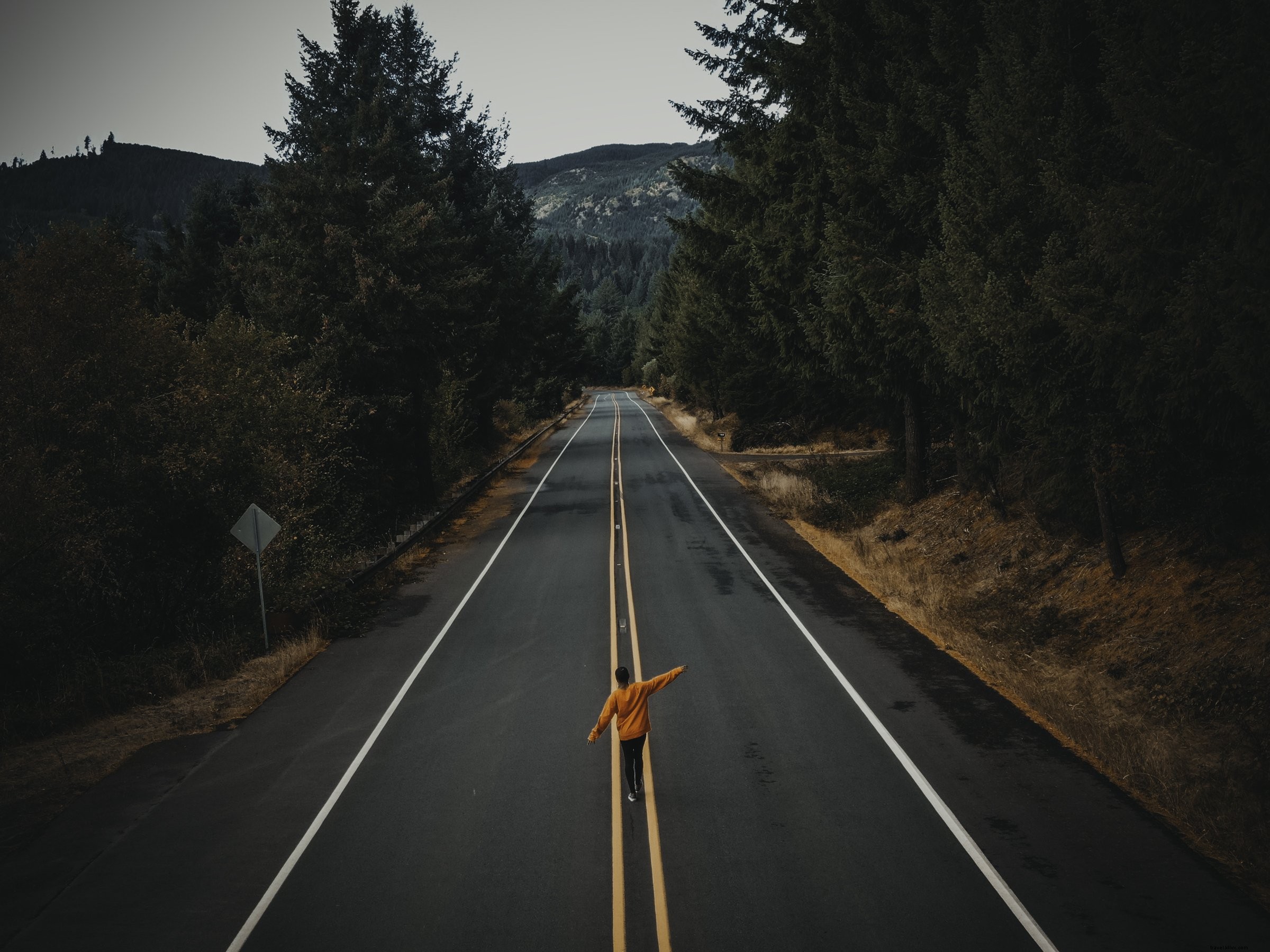 Persona cammina lungo una strada di campagna asfaltata foto 