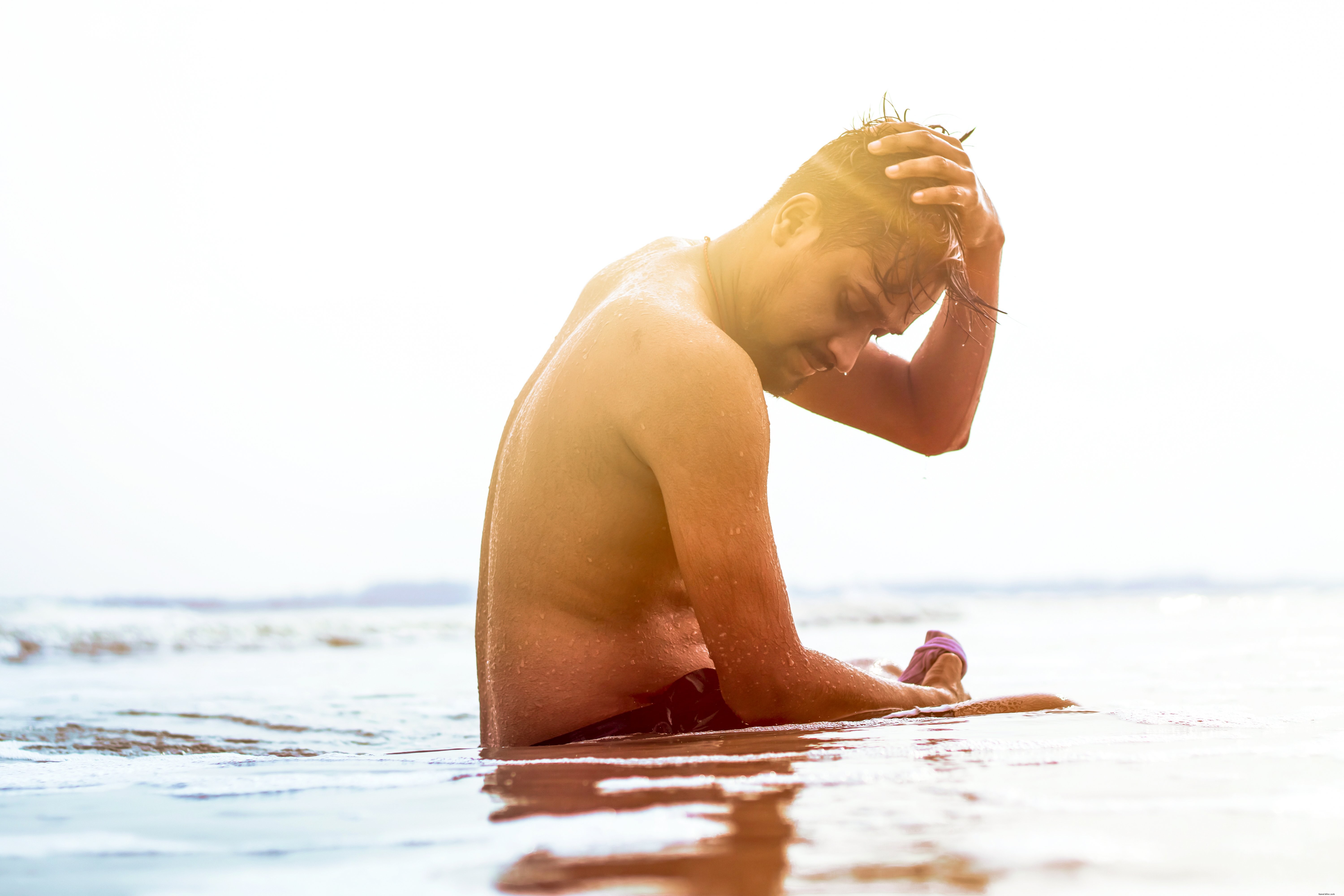 Foto de pessoa sentada em águas rasas em um dia de sol 