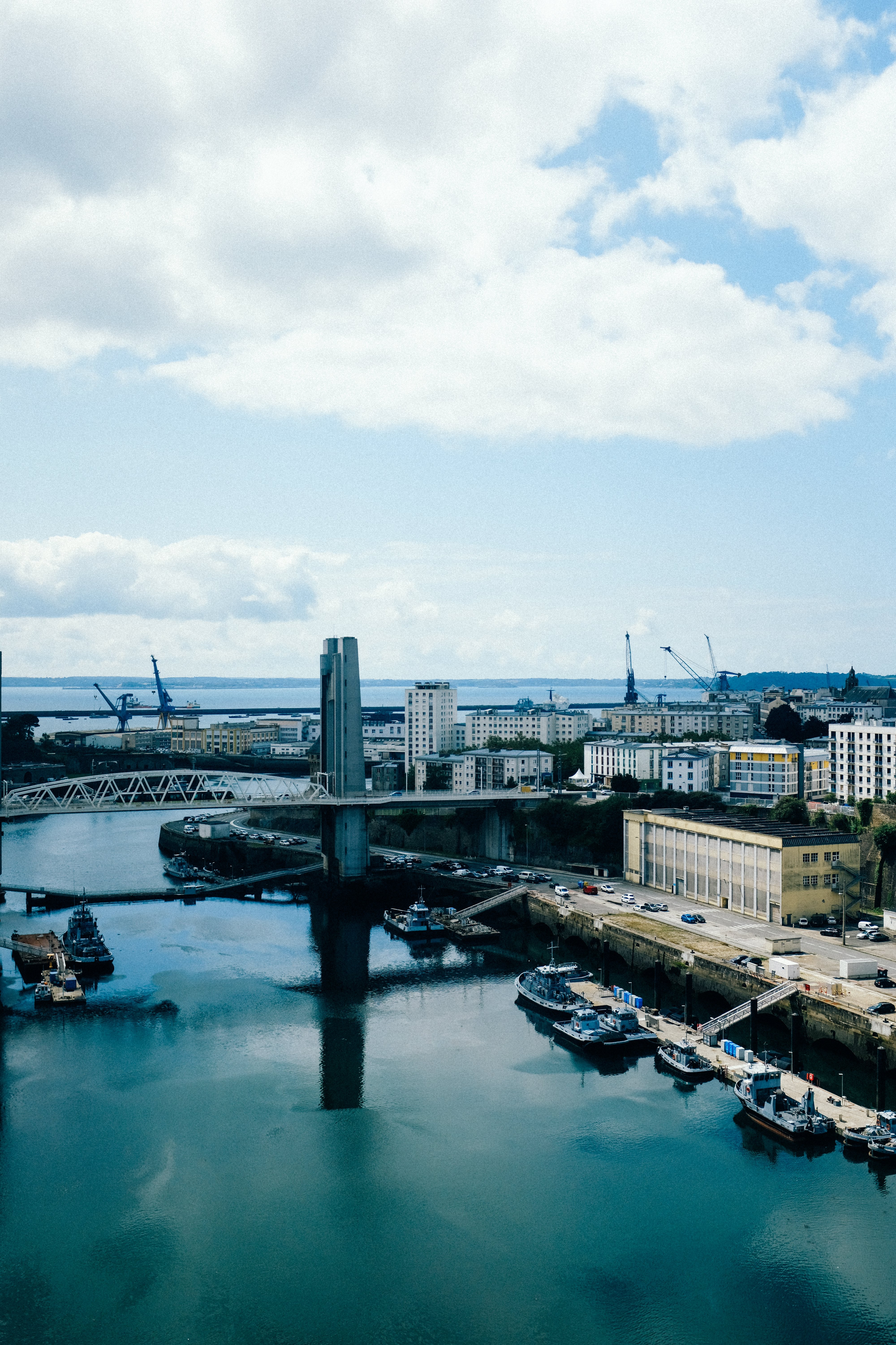 Alta vista de los edificios de la ciudad por el agua azul y los barcos atracados Foto 