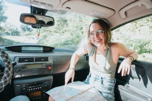 Femme sourit en voiture avec une carte sur ses genoux Photo 