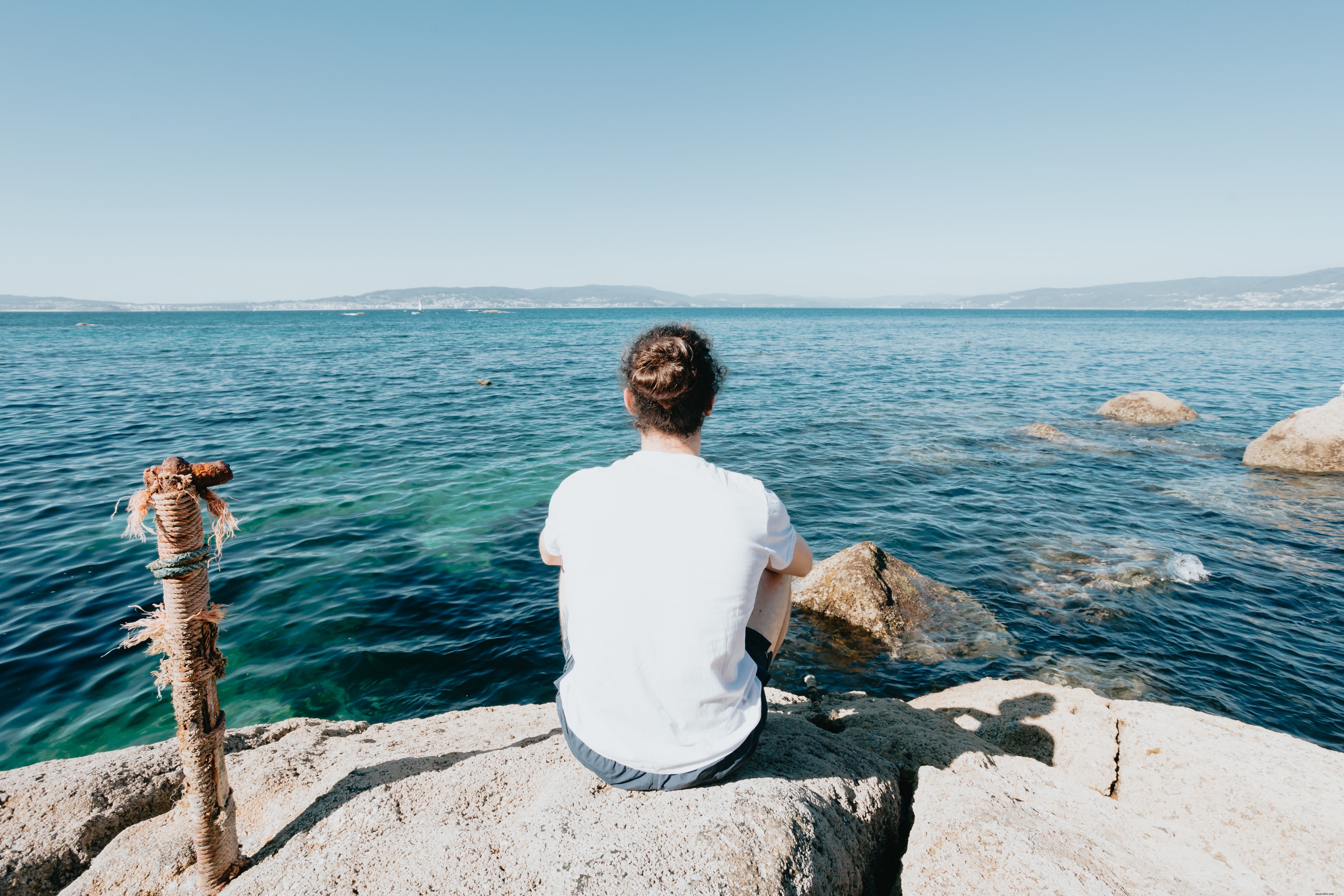 Personne assise sur un rocher et regarde la photo de l eau 