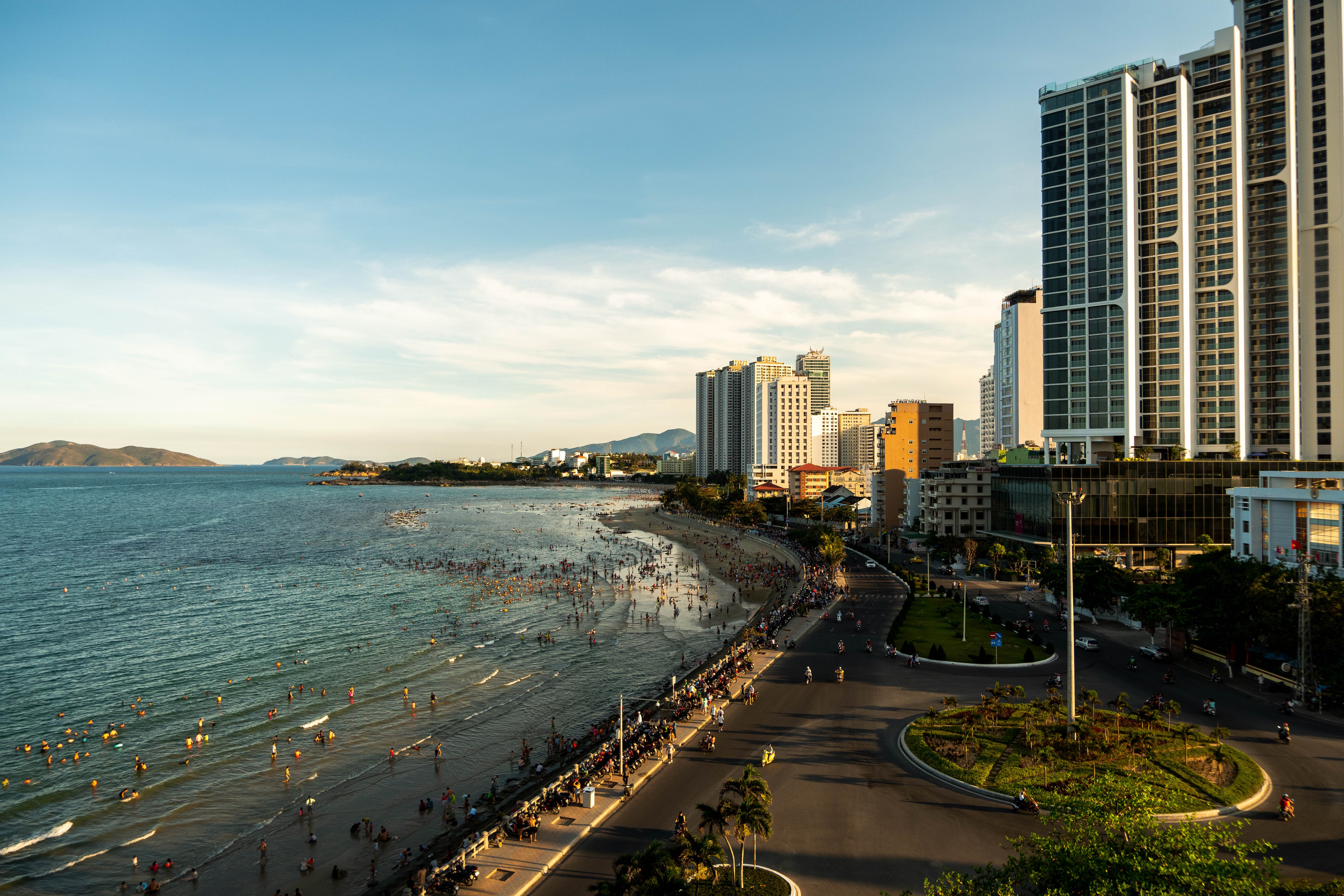 Prédios da cidade lançam sombras ao lado de uma foto de praia pública 