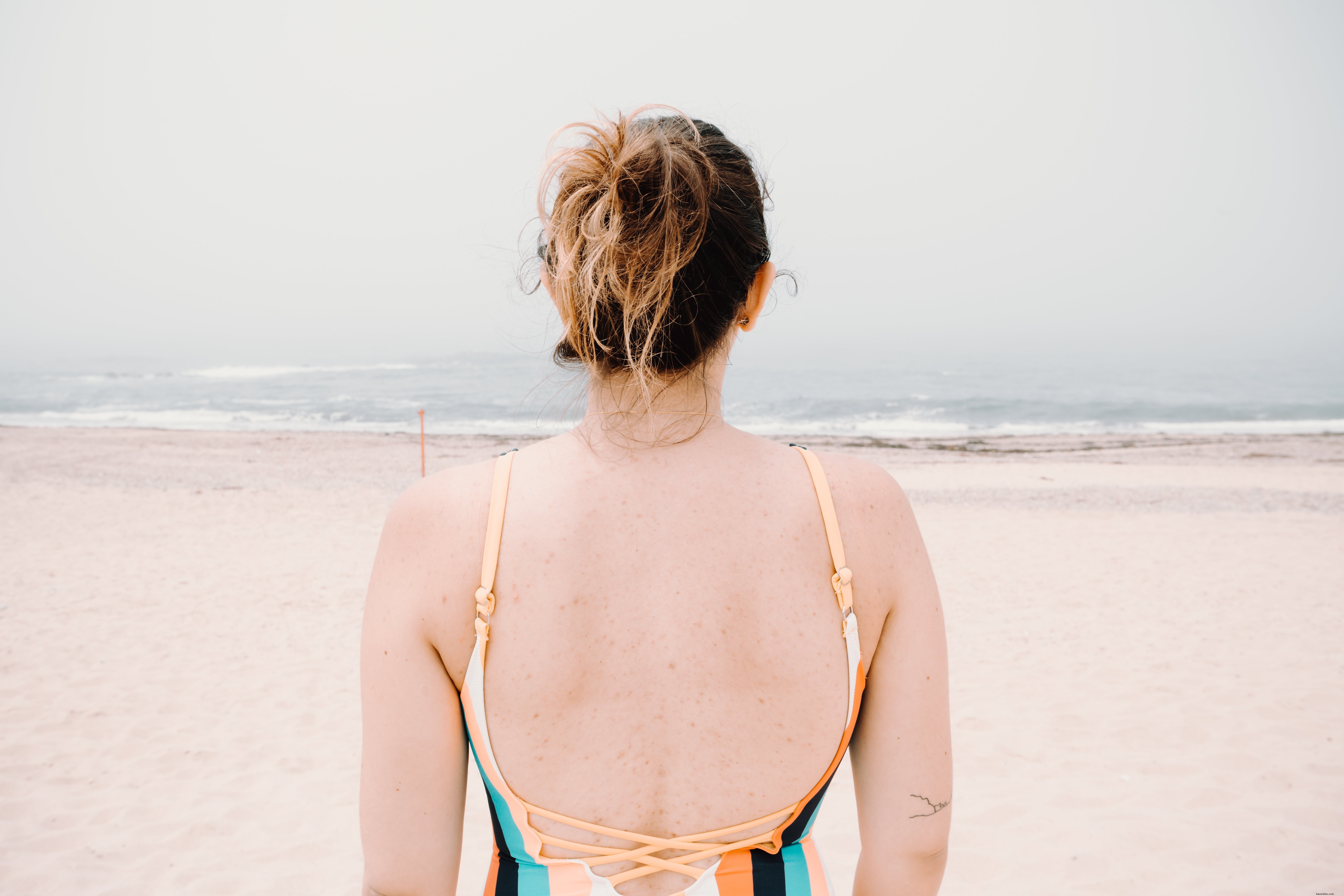 Personne face à l eau ondulée sur une photo de plage de sable 