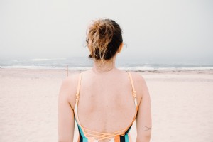 Persona frente al agua ondulada en una playa de arena Foto 